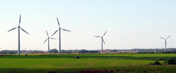 Wind turbines stand tall in the open countryside.