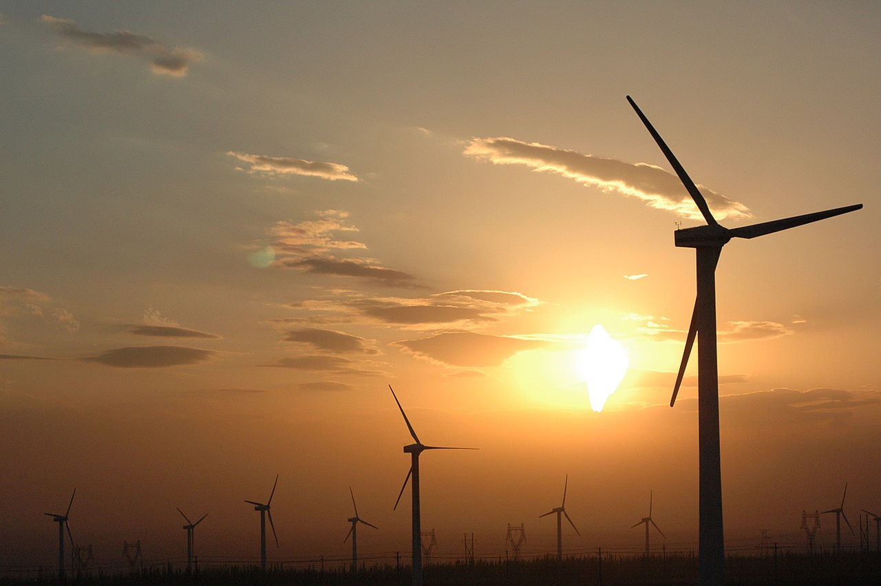 Rows of wind turbines stand tall and spin in the breeze.