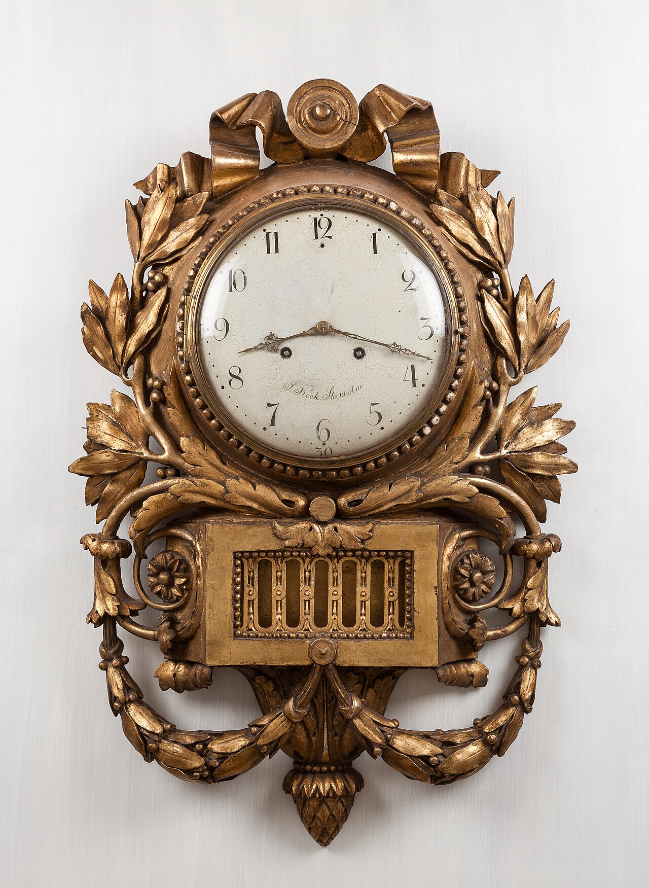 A fancy gold clock with a swinging pendulum.