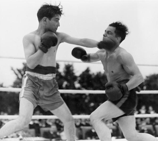Two boxers trade punches in a lively match long ago.